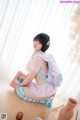 A woman sitting on top of a wooden table holding a book.