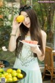 A woman holding a plate of watermelon and a lemon.