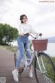 A woman riding a bike with a basket on the back.