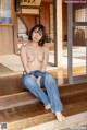 A naked asian woman sitting on a wooden floor.