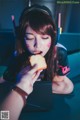 A woman wearing headphones eating a piece of bread.