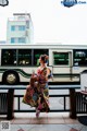 A woman in a colorful kimono is walking down the street.