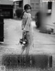 A woman walking down a street holding a bouquet of flowers.