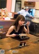 A woman sitting at a table eating a bowl of food.