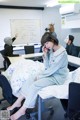 A woman sitting on a bed talking on a cell phone.