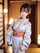 A woman in a blue kimono posing for a picture.