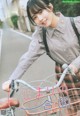 A woman riding a bike with a basket on the back.