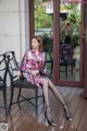 A woman sitting on a chair in front of a door.