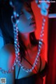 A woman in a black dress with a chain around her neck.