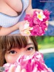 A young girl holding a bunch of pink flowers.