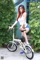 A woman sitting on top of a white bike.