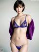 A woman in a purple lingerie posing for a picture.