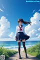 A girl in a school uniform standing on a path by the ocean.