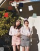 A couple of women standing next to each other in front of a building.